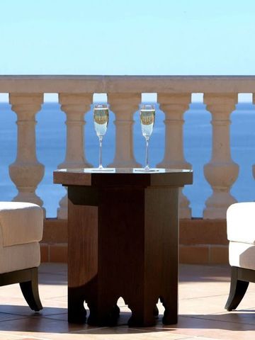 Terrasse mit zwei Sesseln und einem Tisch, Blick auf das Meer