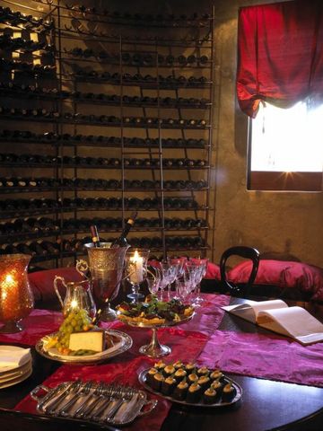 Atmosphärischer Weinkeller mit edler Tischdekoration in der Tintswalo Safari Lodge.