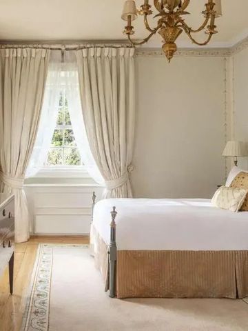 Elegantes Schlafzimmer mit luxuriösen Textilien und antikem Kronleuchter