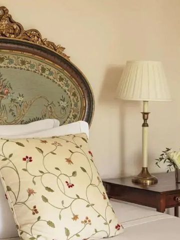 Detailaufnahme eines Bettes mit kunstvoll verziertem Stoffkopfteil