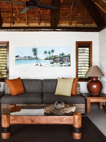 Wohnbereich mit Sofa und tropischem Wandbild