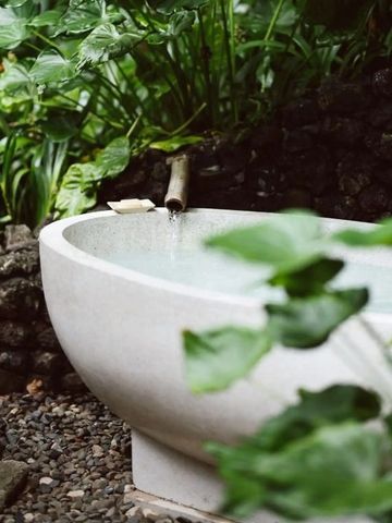 Nahaufnahme einer gefüllten Badewanne im Garten mit fließendem Wasser