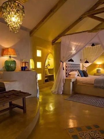 Gemütliches Schlafzimmer in warmen Farben mit Himmelbett und stilvoller Beleuchtung