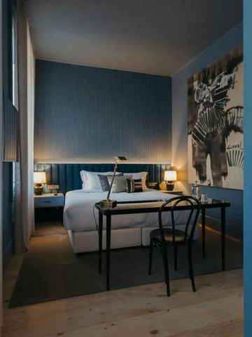 Gemütlich eingerichtetes Hotelzimmer mit modernem Kunstwerk an der Wand