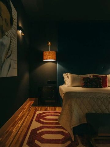 Stilvoll eingerichtetes Zimmer mit Kunstwerk und gemütlichem Bett