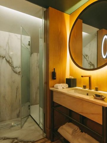 Modernes Badezimmer mit beleuchtetem Spiegel und Glasdusche