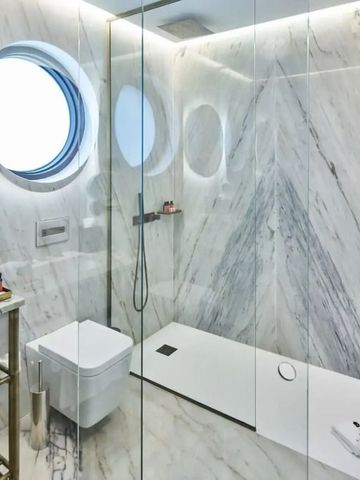 Geräumiges Bad mit großer Dusche und Marmorwänden
