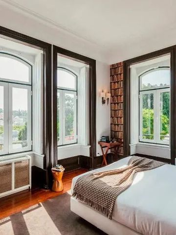 Charmantes Zimmer mit großen Fenstern und Bücherregal als Wanddekoration