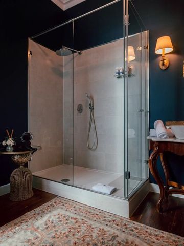 Luxuriöses Badezimmer mit Dusche, antikem Waschbecken und stilvollen Akzenten