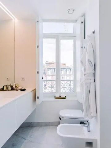 Helles Badezimmer mit großen Spiegeln und elegantem Interieur