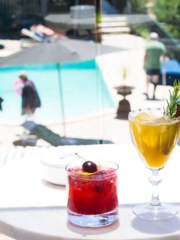 Erfrischende Cocktails auf einem Tisch mit Blick auf den Poolbereich.