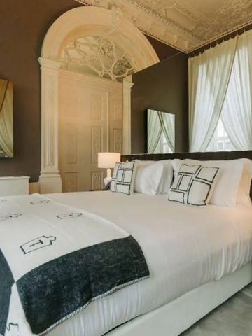 Helles Zimmer mit luxuriösem Bett und klassischen Verzierungen