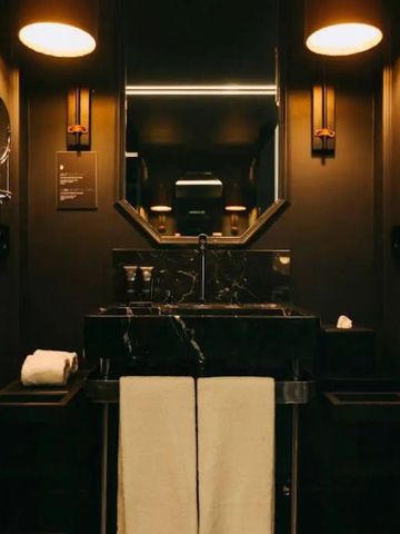 Dunkles modernes Badezimmer mit stilvollen Beleuchtungselementen