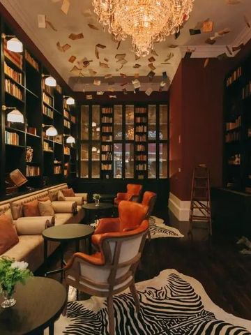 Gemütliche Bibliothek mit edlem Kronleuchter und bequemen Sitzgelegenheiten im Hotel