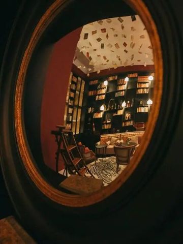 Runder Spiegel mit Blick auf eine stilvolle Bibliothek im Torel Palace Porto