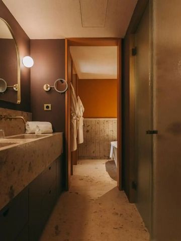 Luxuriöses Badezimmer mit Marmoroberflächen und stilvoller Beleuchtung