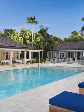 Großer Außenpool mit Sonnenliegen und tropischer Vegetation