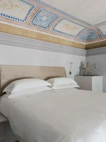 Zimmer mit künstlerisch bemalter Decke und modernem Dekor