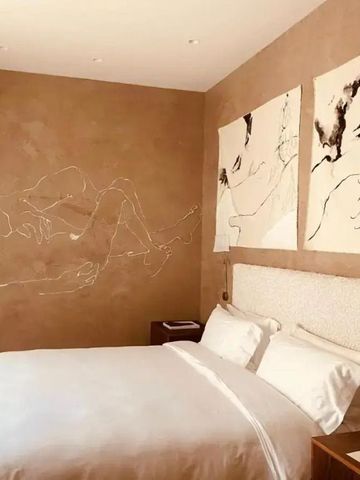 Doppelzimmer mit Kunstwerken an brauner Wand