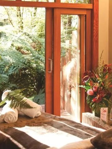 Wellnessraum mit großem Fenster Blick auf grüne Natur