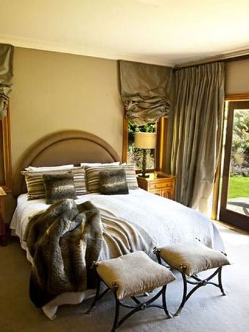 Luxuriöses Hotelzimmer mit großem Bett, eleganter Einrichtung und Blick auf den Garten