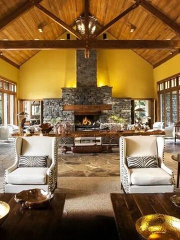 Großzügige, rustikale Hotellounge mit Kamin und Holzbalkendecke