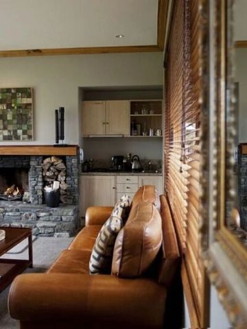 Gemütlicher Wohnbereich mit Ledersofa und Kamin aus Naturstein