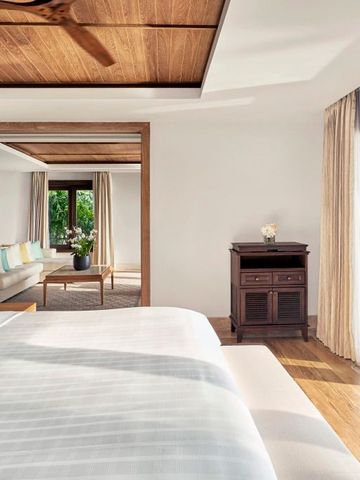 Helles Zimmer im Resort mit großem Bett und Zugang zu einer privaten Terrasse.