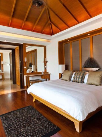 Luxuriöses Schlafzimmer im tropischen Stil mit Zugang zu einem stilvollen Bad.