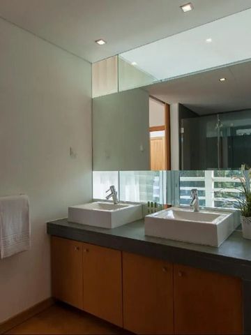 Elegantes Badezimmer mit Doppelwaschtisch, großen Spiegeln und moderner Einrichtung.