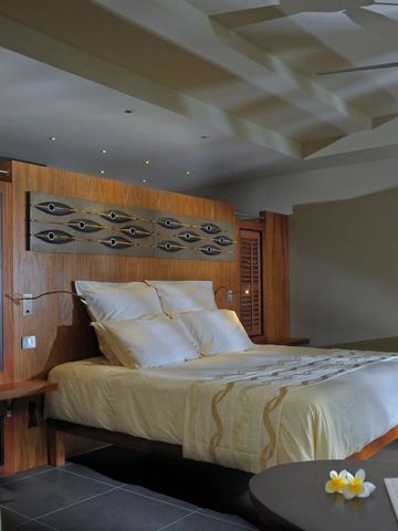 Luxuriöses Hotelzimmer mit großem Bett und moderner Einrichtung im Tropenstil