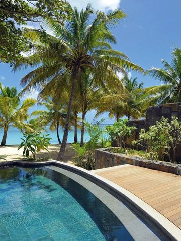 Infinity Pool umgeben von Palmen mit Blick auf den Strand