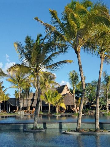 Palmen und Architektur am Poolbereich des Trou aux Biches Beachcomber