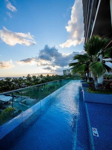 Infinity-Pool am Rand eines modernen Gebäudes mit Meerblick