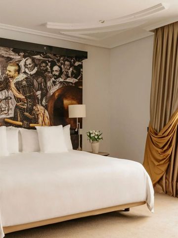 Luxuriöses Hotelzimmer mit großem Bett und künstlerischer Wanddekoration.