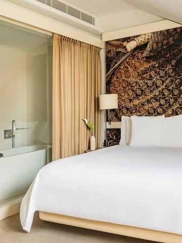 Geräumiges Hotelzimmer mit Badewanne und kunstvoller Wandgestaltung.