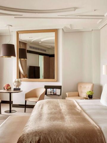 Helles Hotelzimmer mit Spiegel und eleganter Sitzgelegenheit