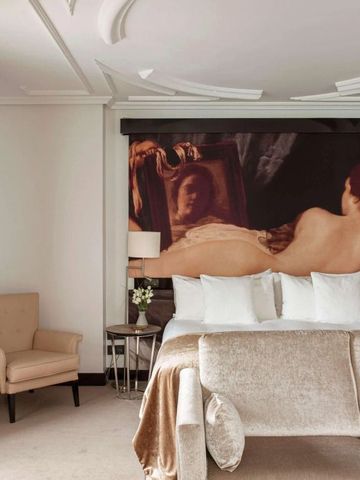 Geschmackvoll eingerichtetes Zimmer mit großem Gemälde und komfortabler Sitzgruppe