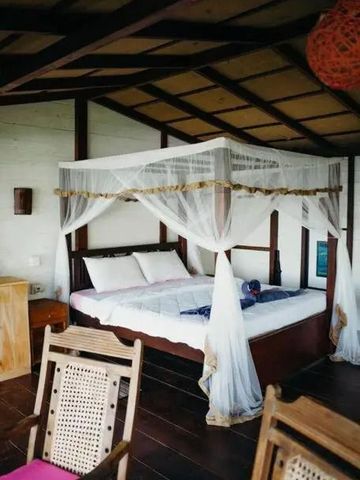 Zimmer mit Himmelbett und Holzdekor