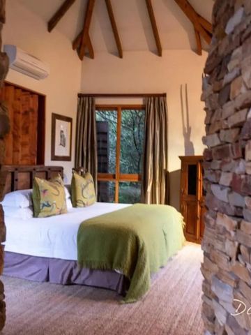 Schlafzimmer im Tsala Treetop Lodge mit rustikalen Holzakzenten und Naturblick