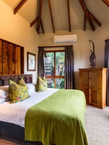 Luxuriöses Schlafzimmer mit modernen Möbeln und grüner Akzentdecke