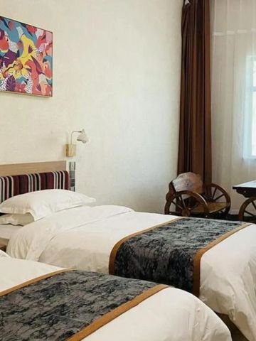 Helles Hotelzimmer mit zwei Einzelbetten und bunter Wandkunst