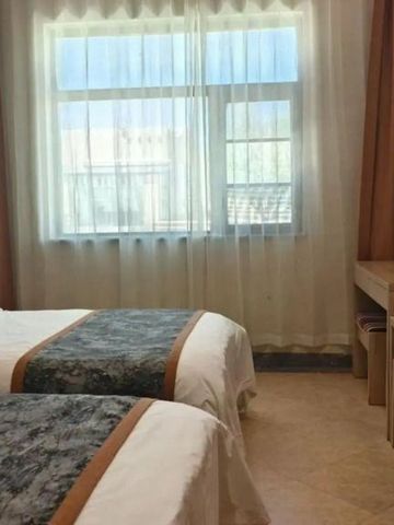 Helles Zimmer mit zwei Einzelbetten und großem Fenster