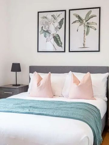 Schlafzimmer mit farblich abgestimmten Textilien und Kunstwerken