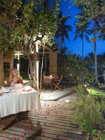 Paar genießt romantisches Abendessen im Garten unter Palmen