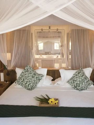 Elegantes Hotelzimmer mit Himmelbett und Dekokissen