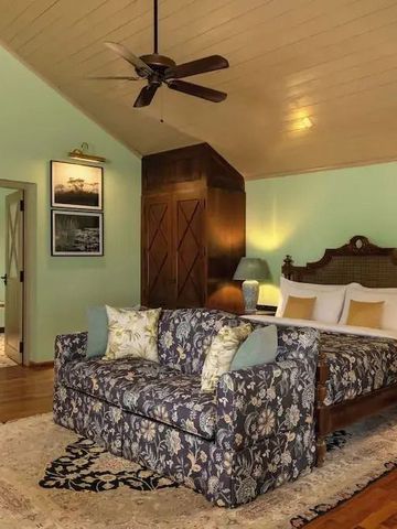 Raffiniertes Schlafzimmer mit Sitzbereich und Holzdecke im UGA Halloowella Hotel