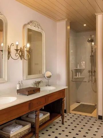 Modernes Badezimmer mit Doppelwaschbecken und eleganten Wandlampen.