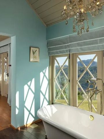 Luxuriöses Badezimmer mit freistehender Badewanne und Panoramablick auf die Berge