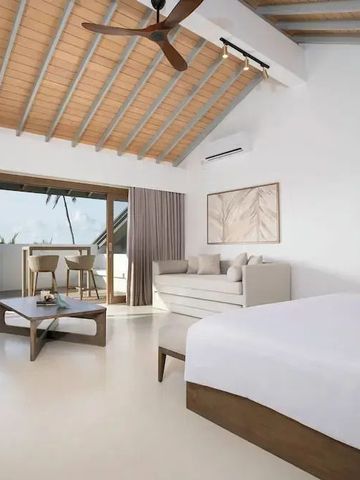 Helles Zimmer mit moderner Einrichtung und Balkon mit Meerblick